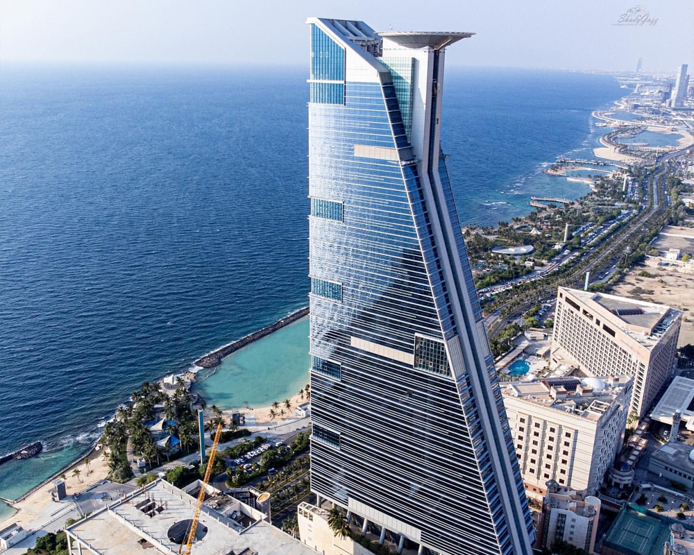 Aerial view of a modern Jeddah waterfront tower and the Red Sea
